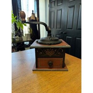 Antique manual coffee grinder, featuring a wooden box with folk art